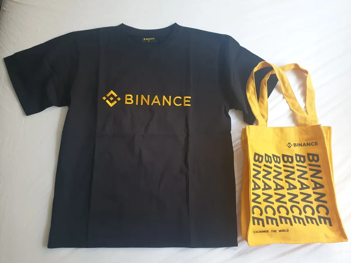 Black Binance T-shirt and yellow Binance bag photographed in July 2022