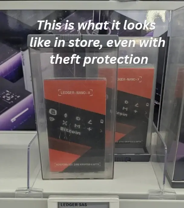 Ledger Nano X retail package inside a transparent shop anti-theft box, photographed by Johannes