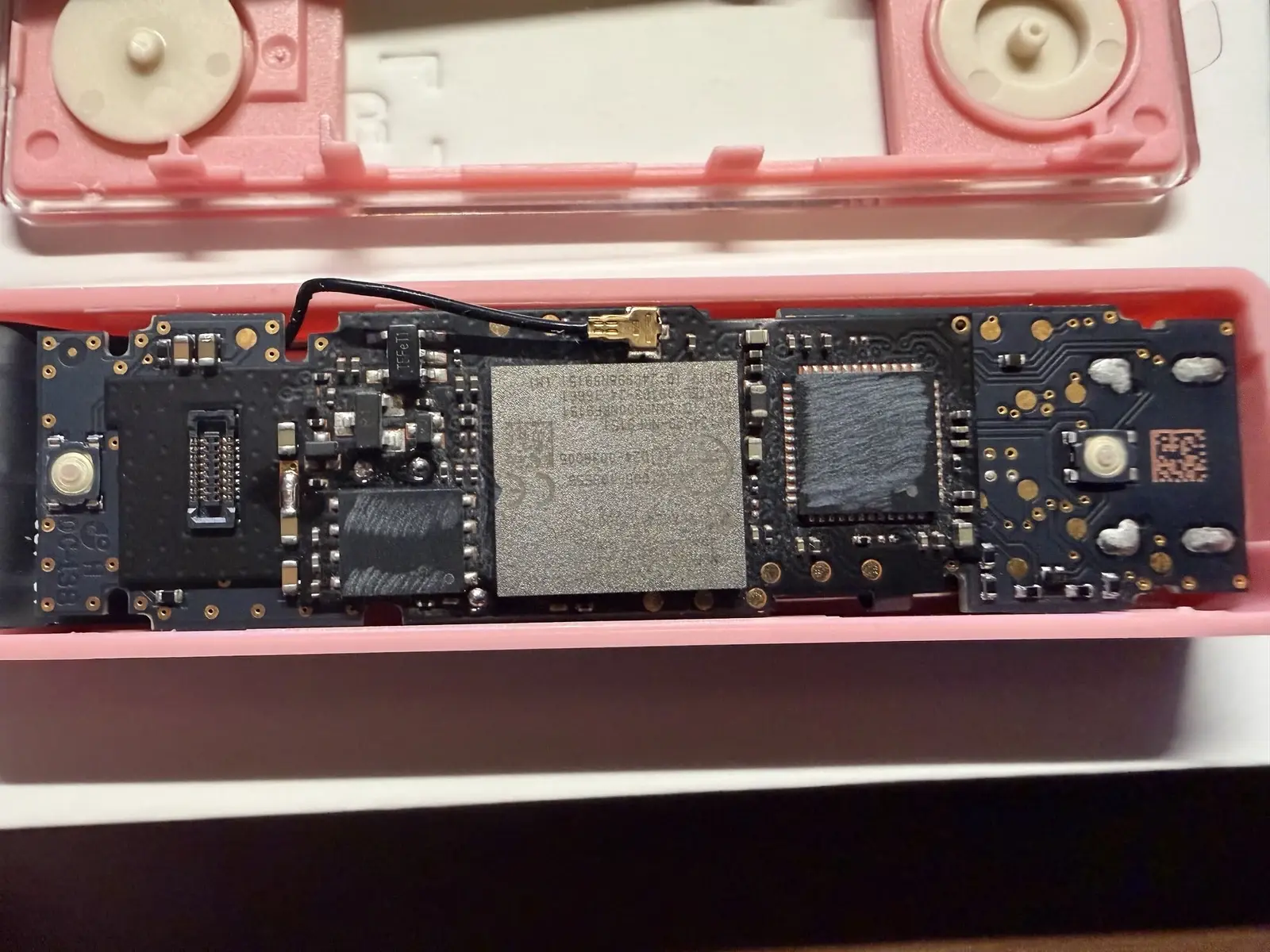 Tibane Labs research specimen with the screen removed, exposing a concealed board, metal cellular module and looped antenna cable inside a pink Nano X enclosure